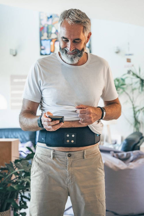 A man adjusting the Compex ComfortTENS Back Wrap 