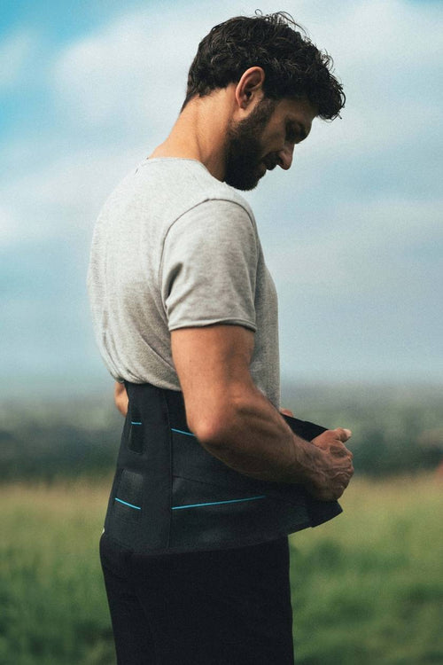 A man putting on the Compex Activ' Back Belt