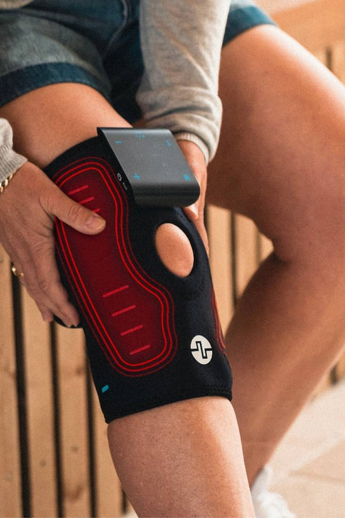A woman putting on the Compex ComfortTENS Knee Wrap