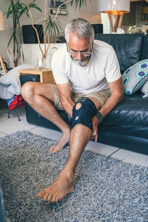 A man putting on the Compex ComfortTENS Knee Wrap