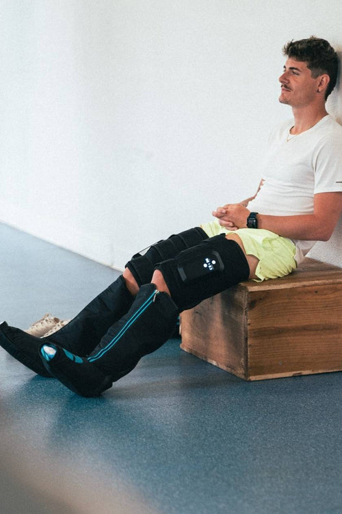 A man relaxing using the Compex Ayre wireless compression boots