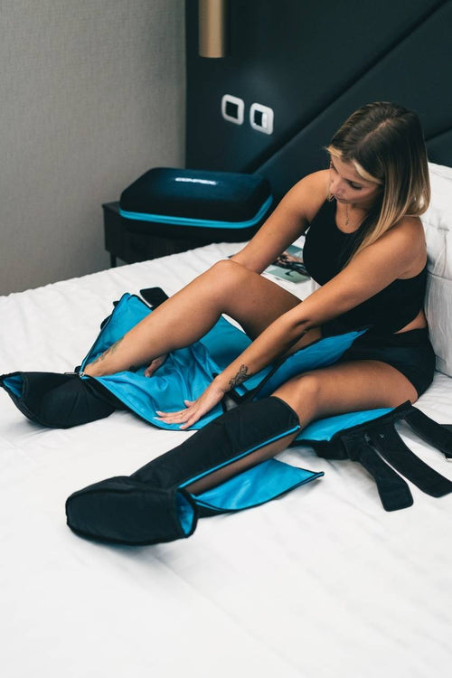 A woman putting on the Compex Ayre wireless compression boots