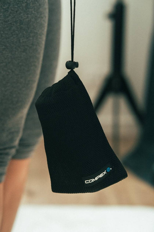 The Compex Fixx™ Mini massage gun in its duffle bag