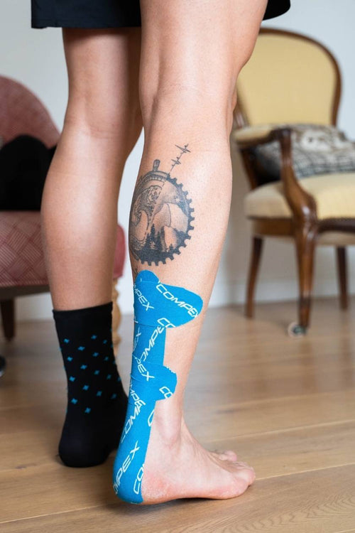 A man with blue Compex K-Tape on his achilles tendon