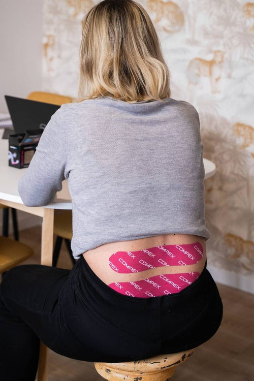A woman with pink Compex K-Tape across her back