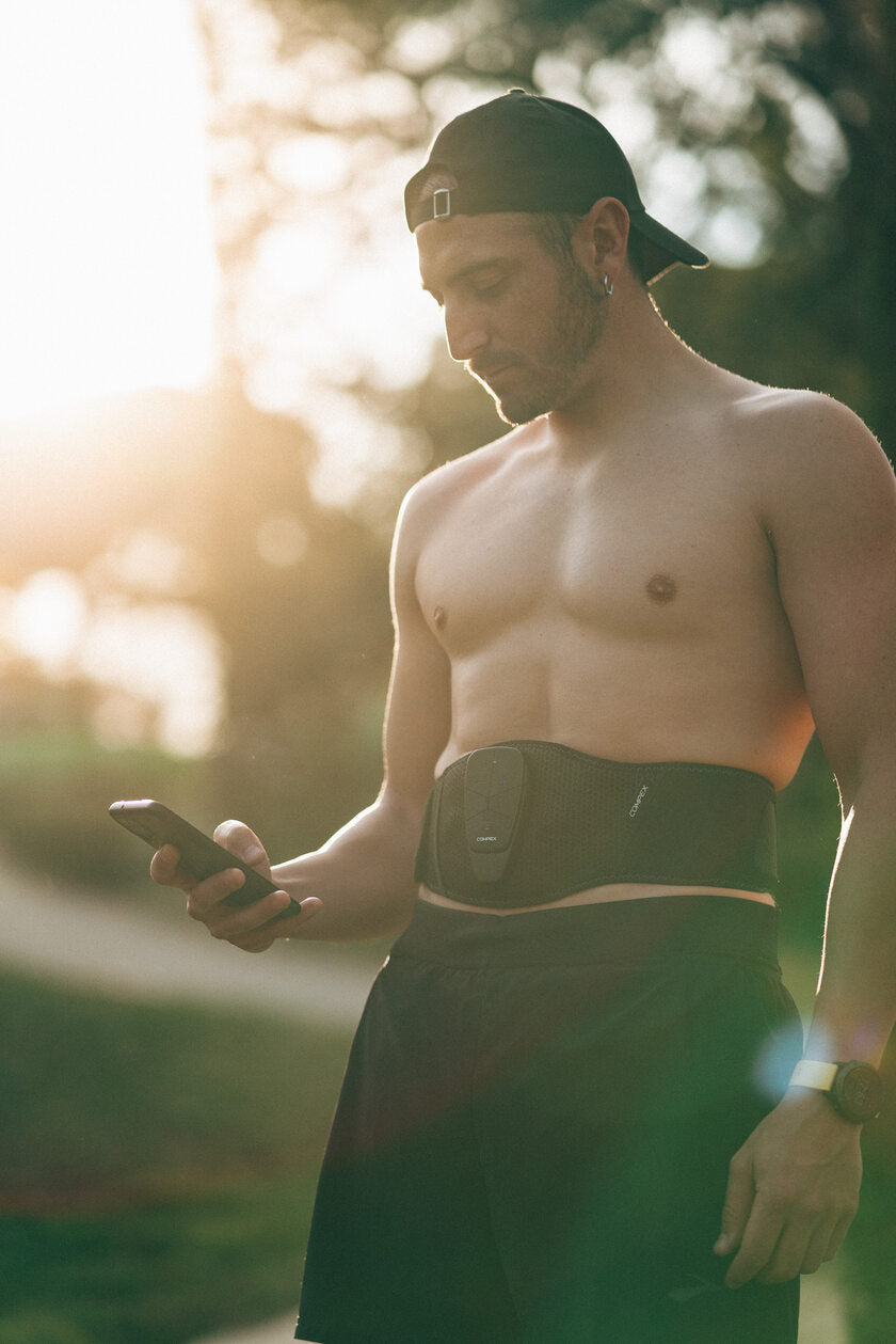 A man using the Compex Corebelt EMS muscle stimulator belt