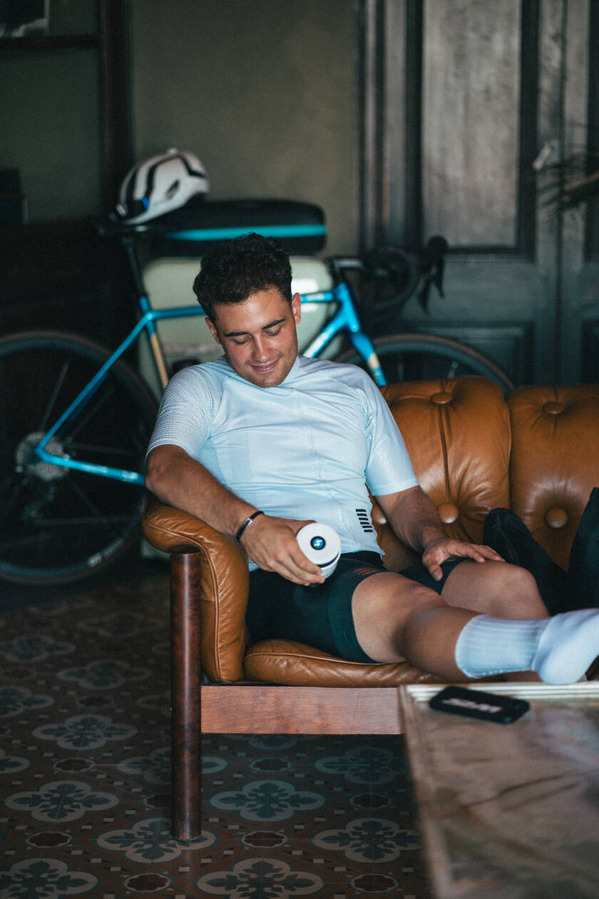 A man using the Compex Fixx Mini massage gun on his quads