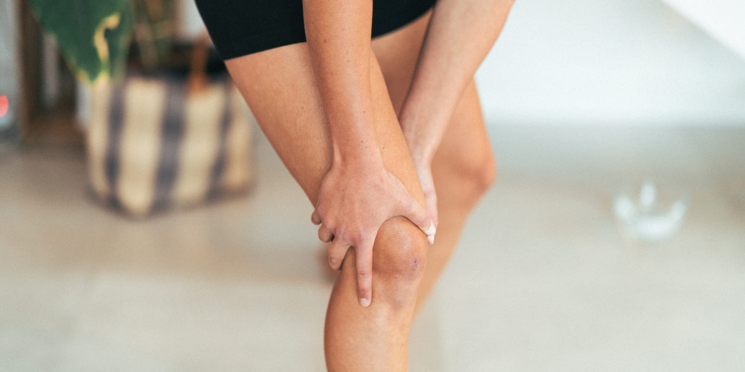 A woman holding her knee due to knee pain