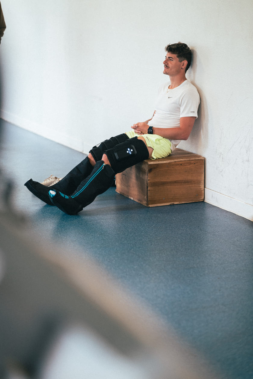 A man relaxing using the Compex Ayre™ compression boots