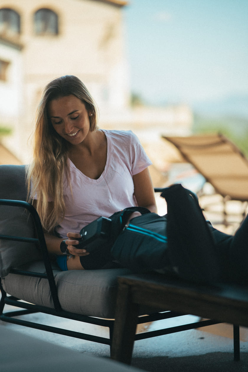 A woman adjusting the intensity on the Compex Ayre™ compression boots