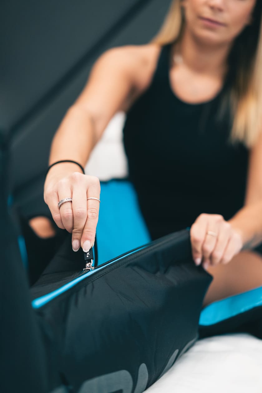 A woman zipping up the Compex Ayre™ compression boots
