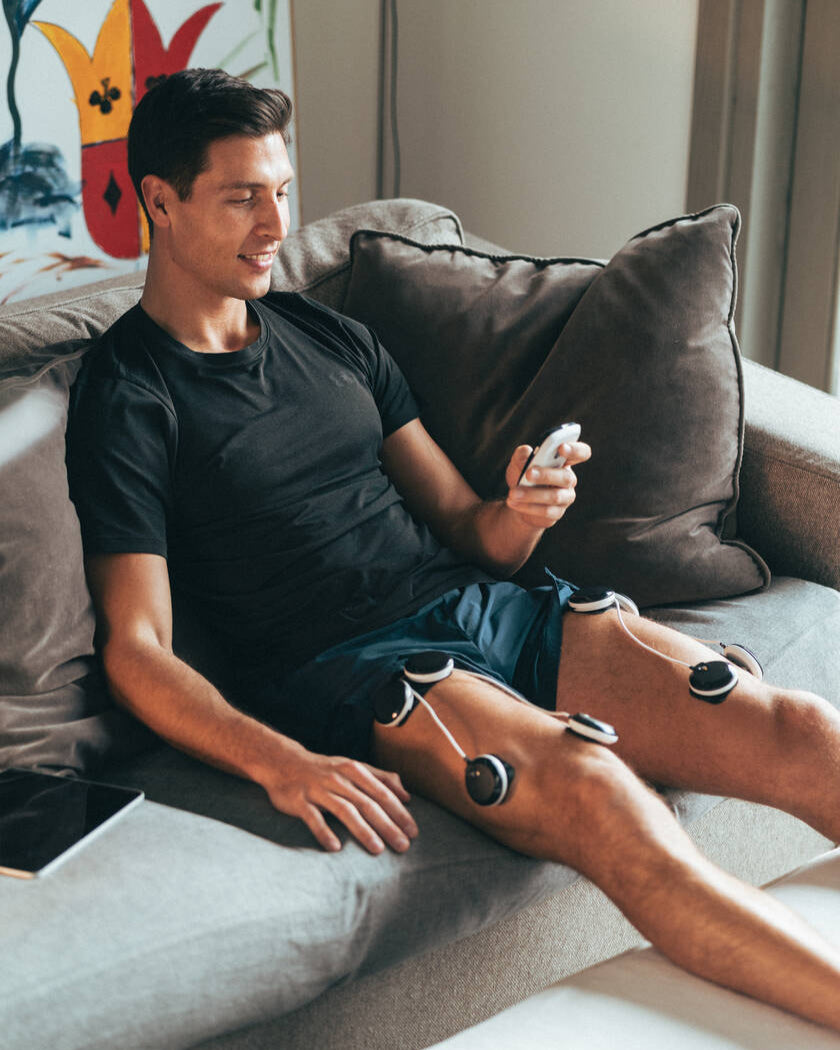 A man doing quad muscle recovery using the Compex SP 8.0 EMS muscle stimulator