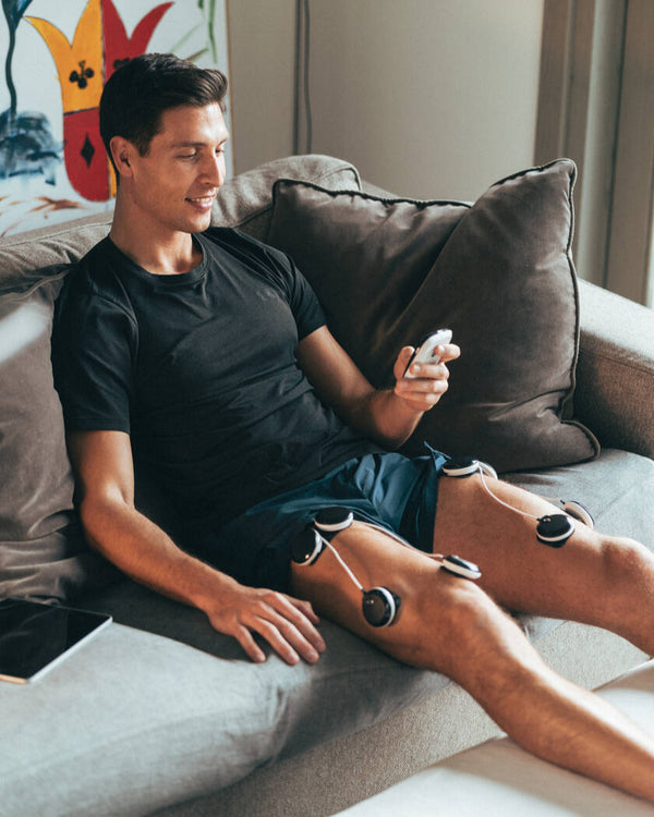 A man doing quad muscle recovery using the Compex SP 8.0 EMS muscle stimulator