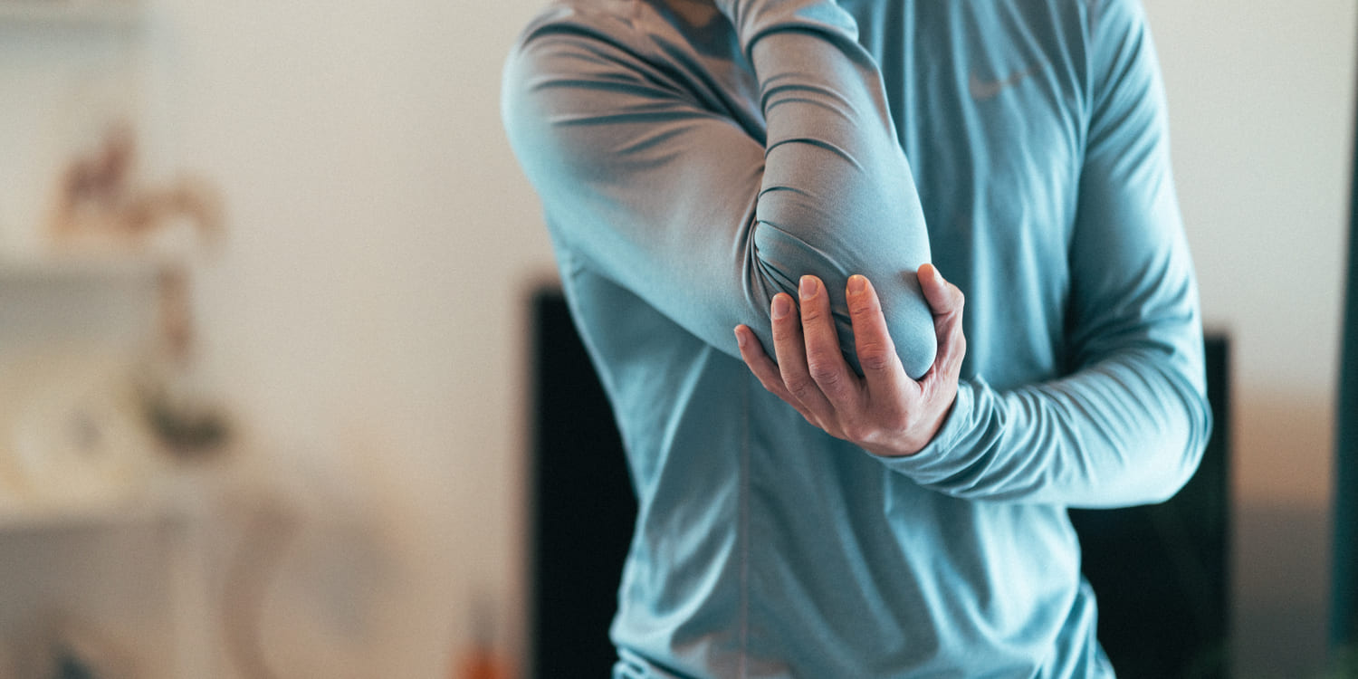 A man holding his elbow due to pain