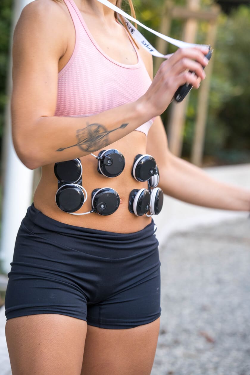 A woman improving her abs using the Compex SP 8.0 EMS muscle stimulator