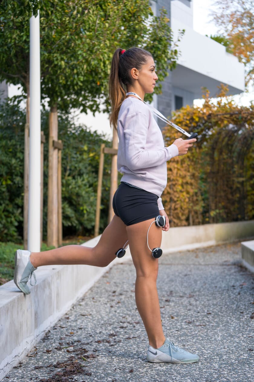 A woman working on toning her thighs using the Compex SP 8.0 EMS muscle stimulator