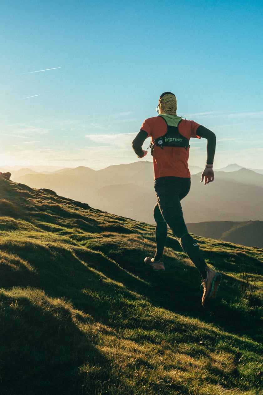 A man running up a steep hill trail