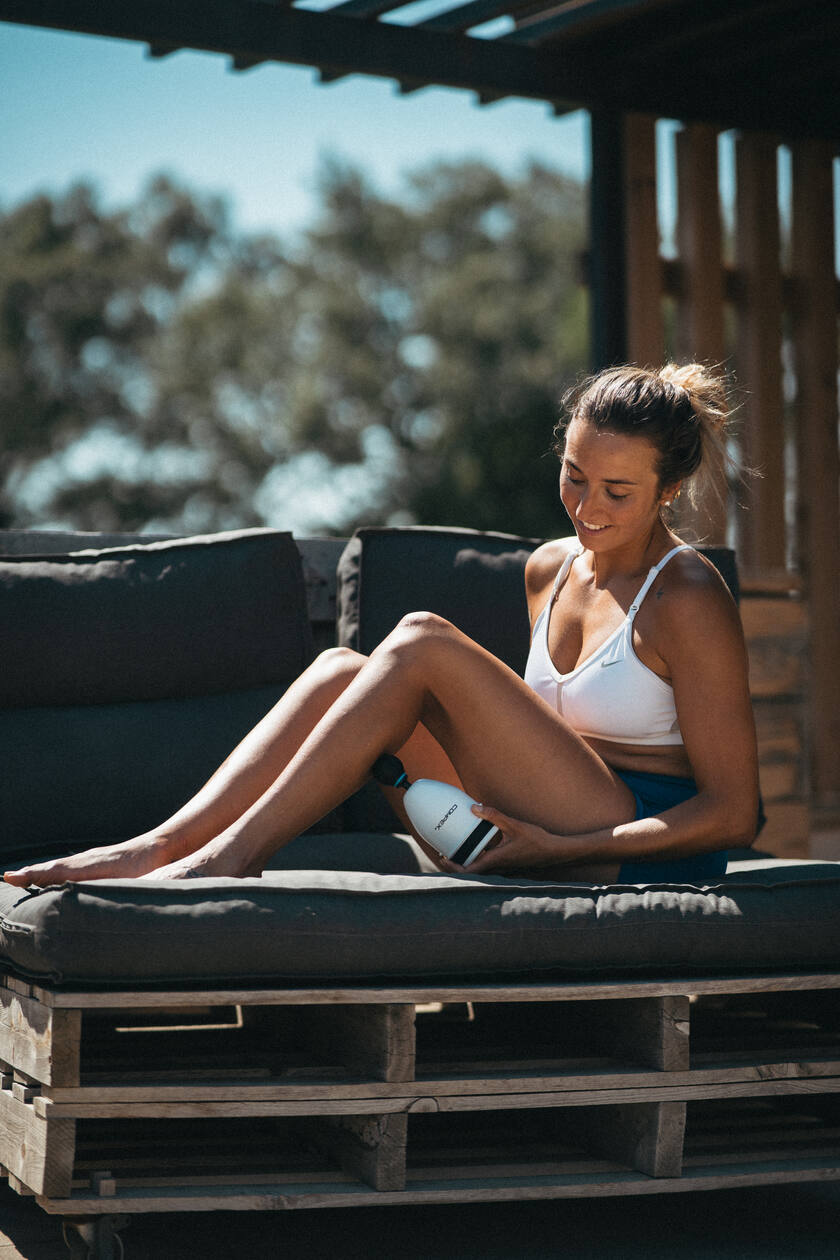 A woman using the Compex Fixx™ Mini to massage her calf muscles