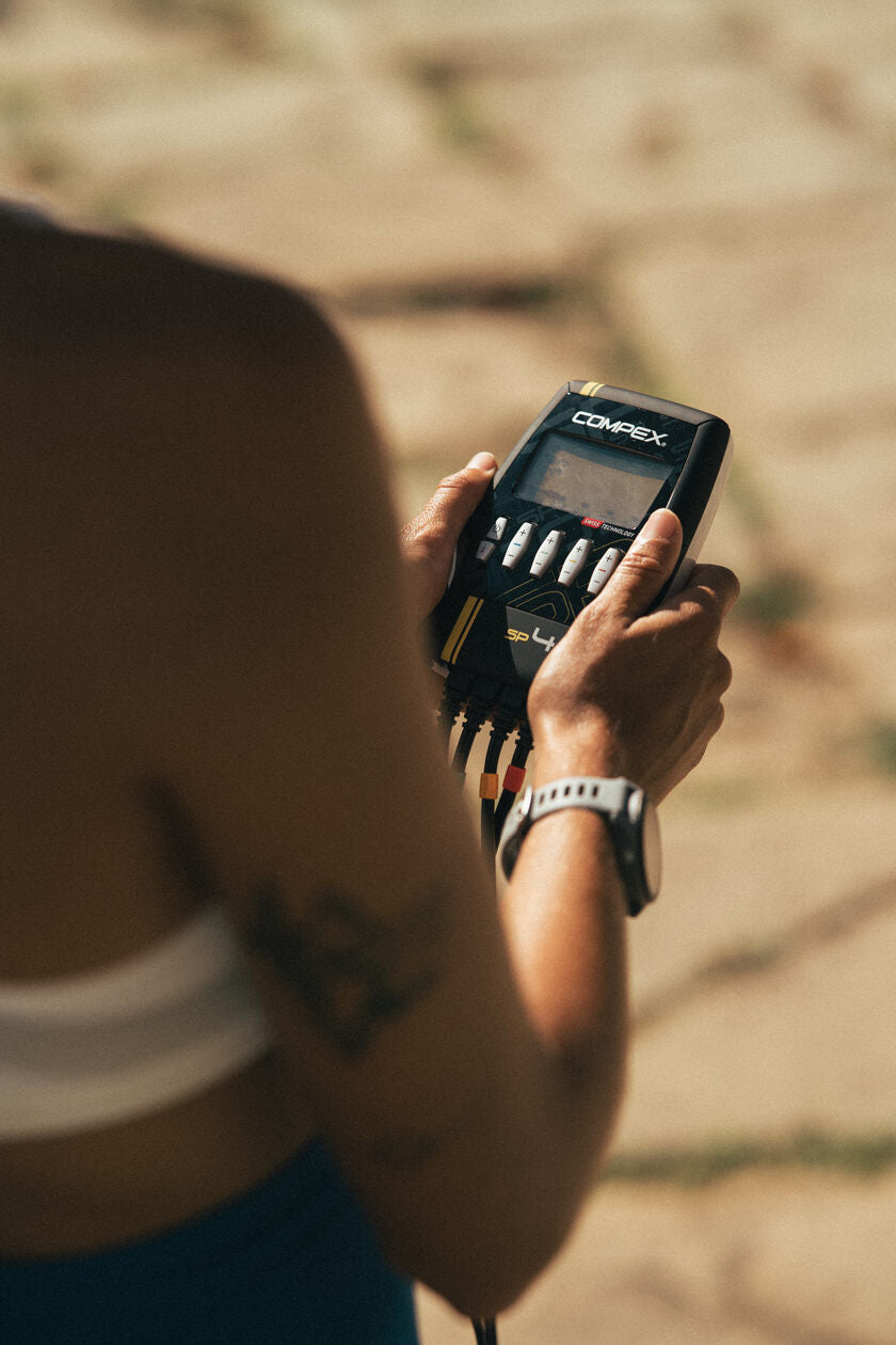 A woman using the Compex SP 4.0 to tone her muscles