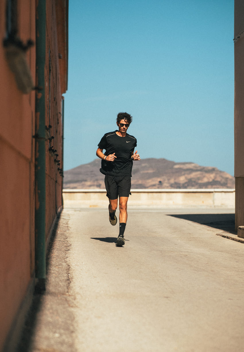 Man running on a path with mountains in the background