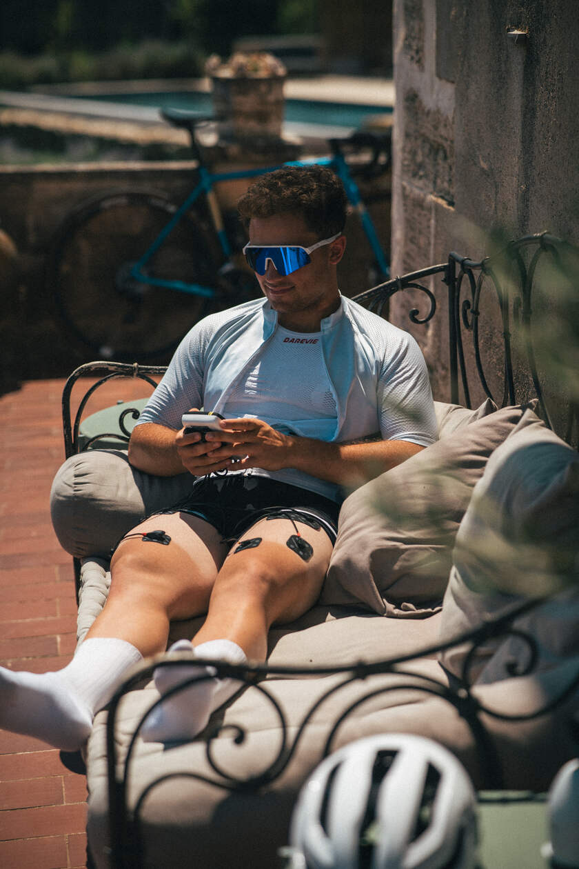 A man using the Compex SP 4.0 EMS muscle stimulator to do recovery on his quads