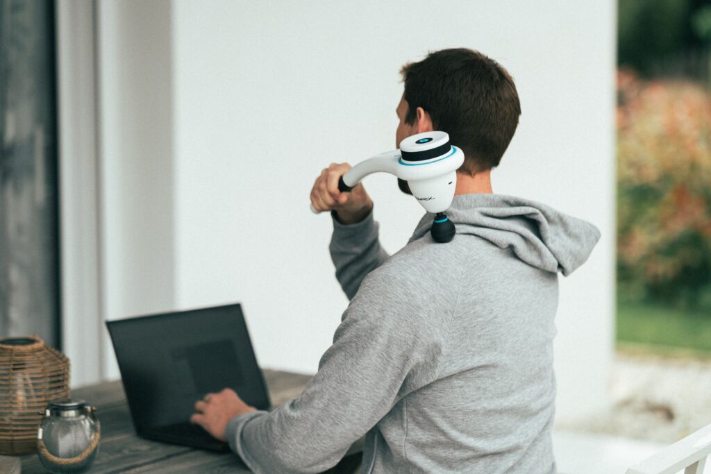 un homme utilisant un pistolet de massage compex fixx