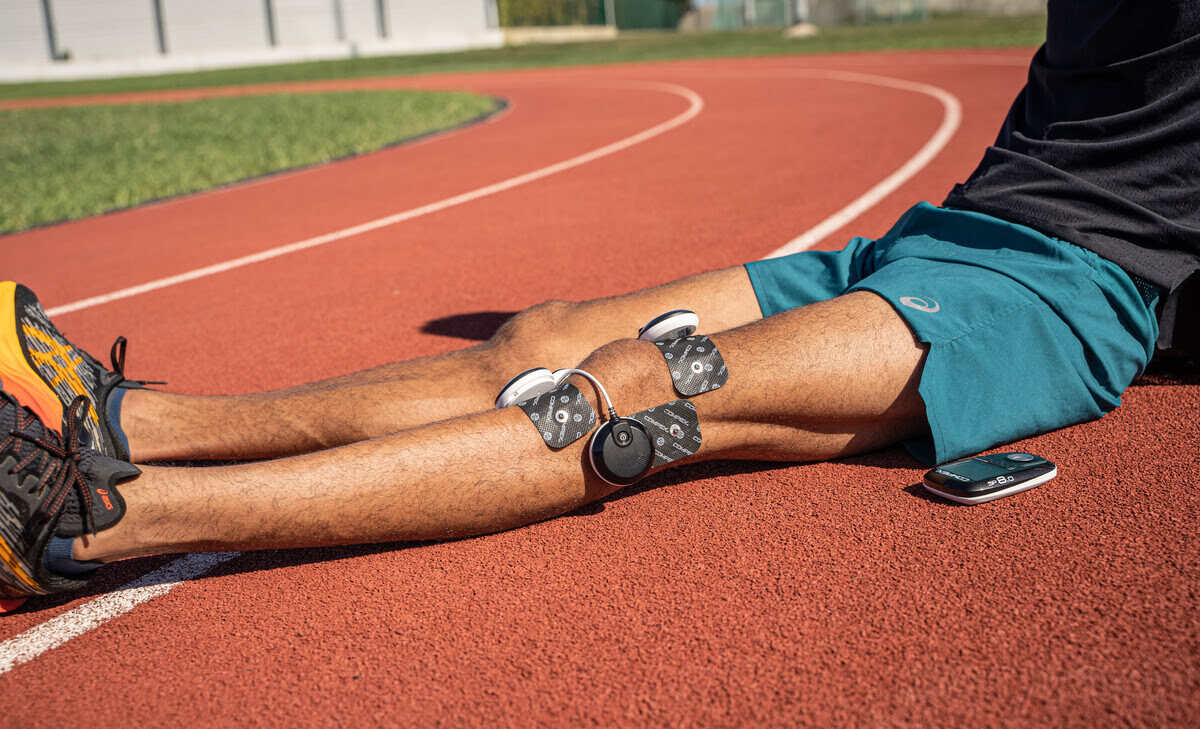 An athlete managing knee pain with Compex TENS program