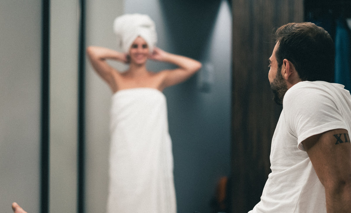 A woman wearing a towel after finishing her shower morning routine