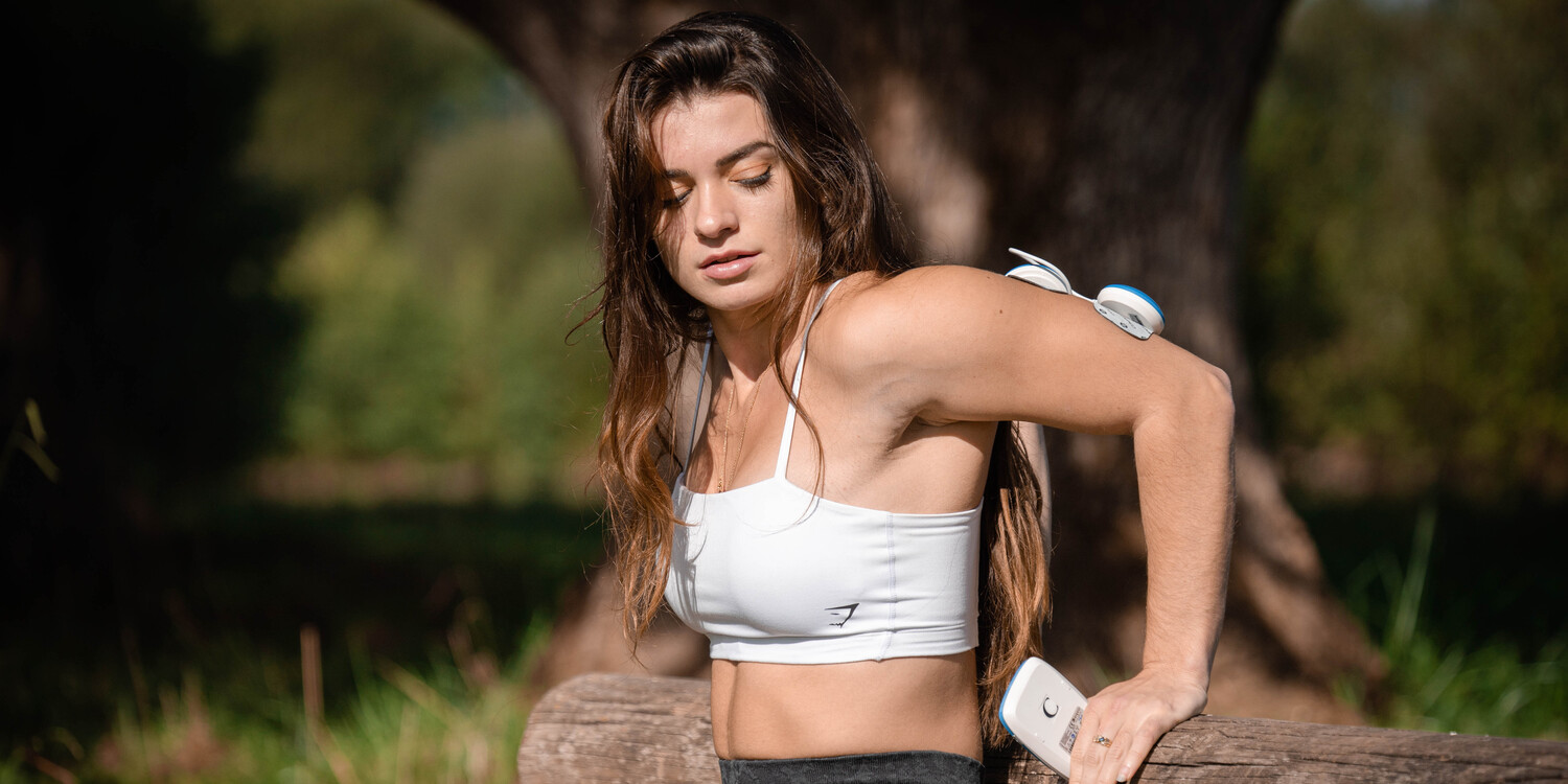 A woman doing a tricep dips to get toned arms using the Compex FIT 5.0 muscle stimulator
