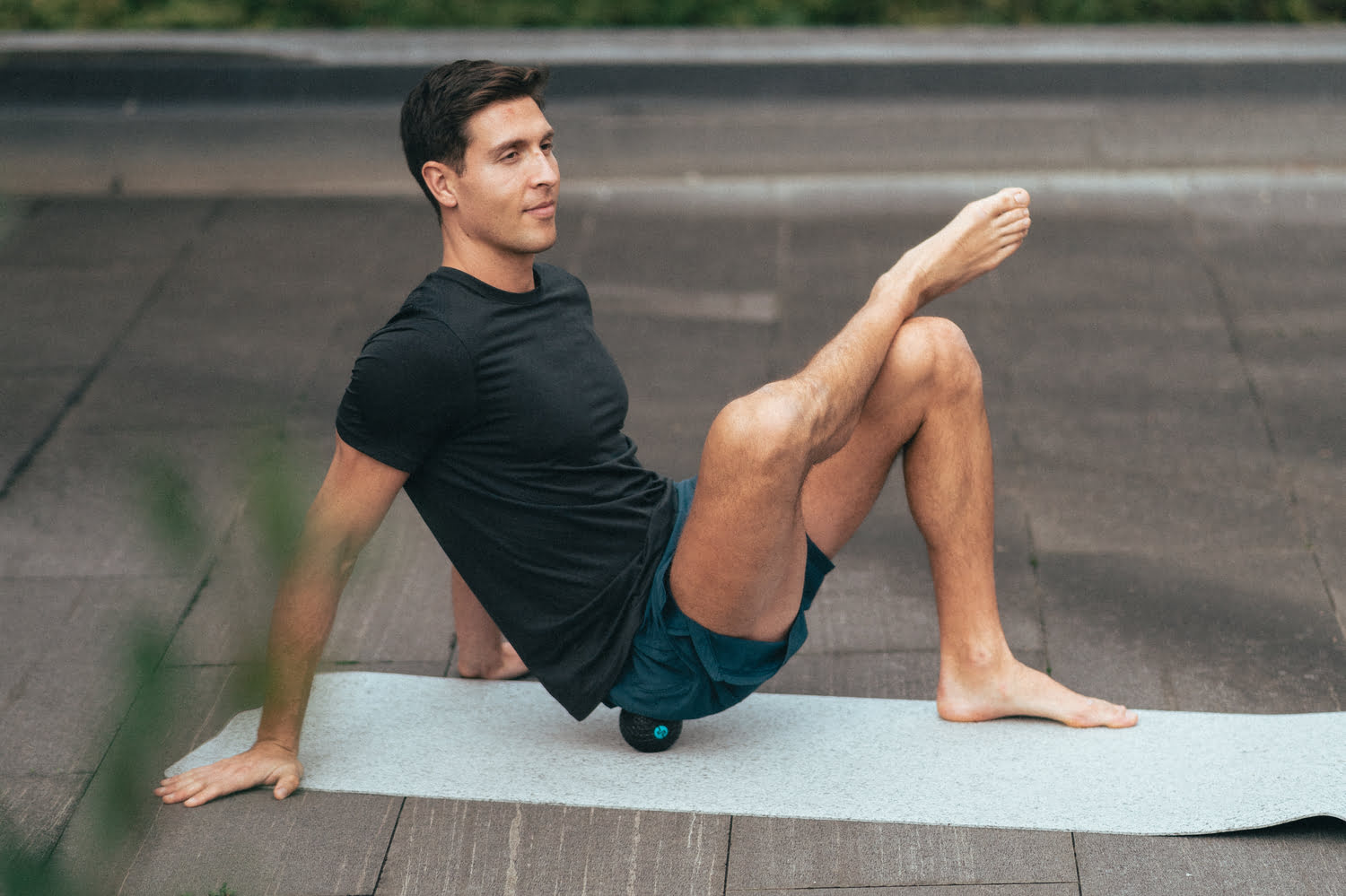 un homme massant ses fessiers avec la balle vibrante compex molecule
