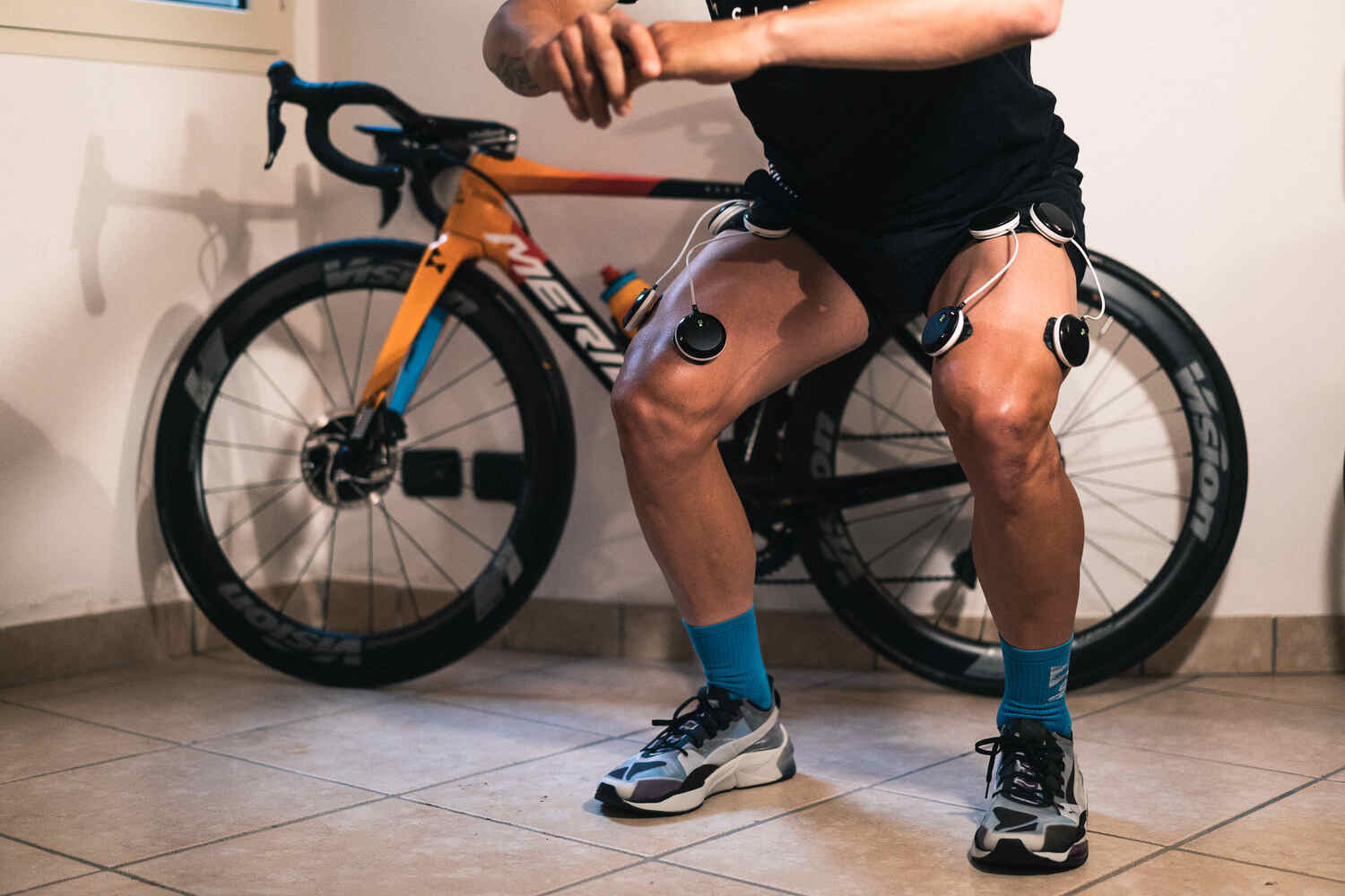 A cyclist using the Compex SP 8.0 to build muscle doing squats