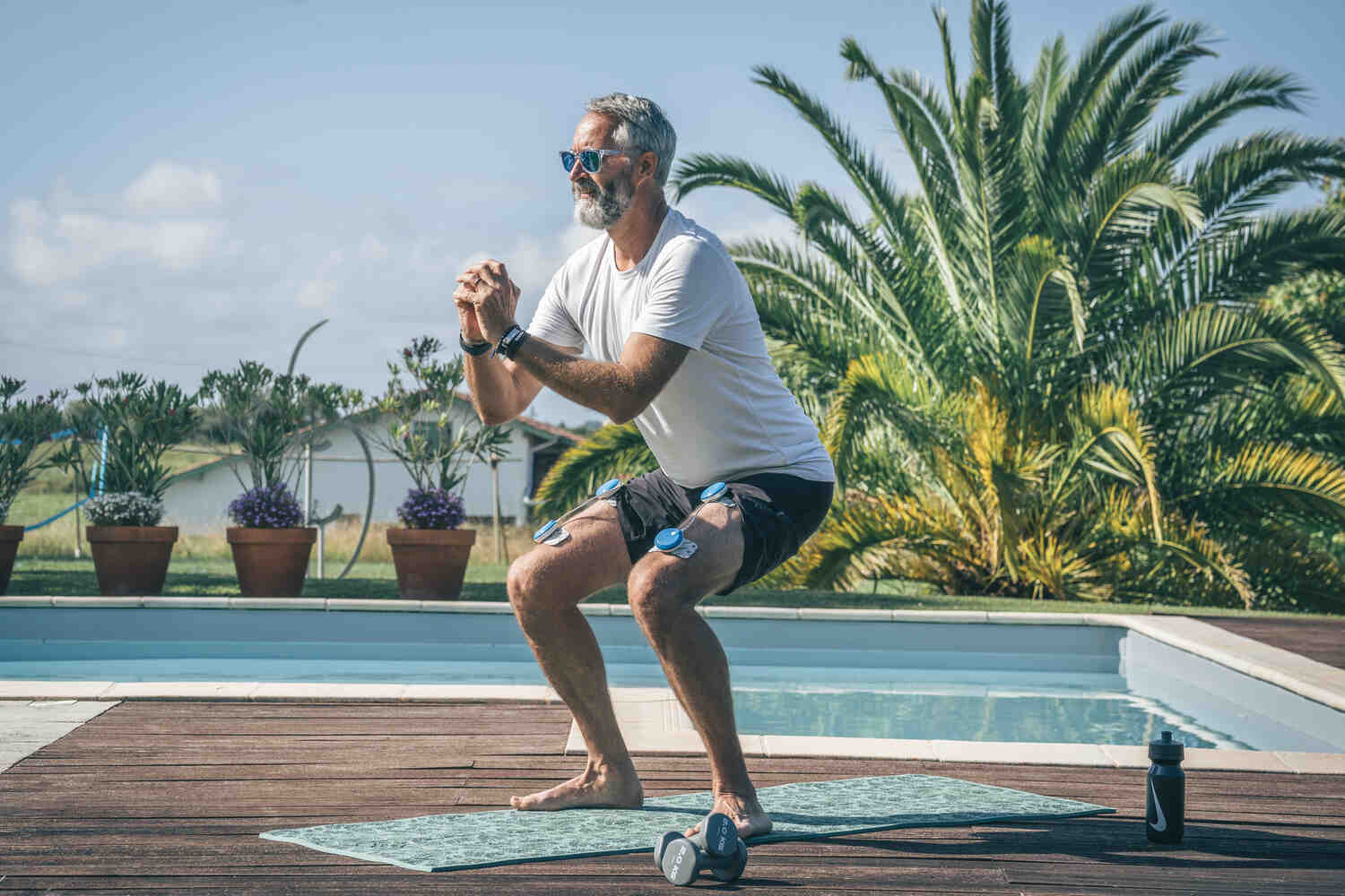 A man using the Compex FIT 5.0 electrostimulator to work out his quad muscle