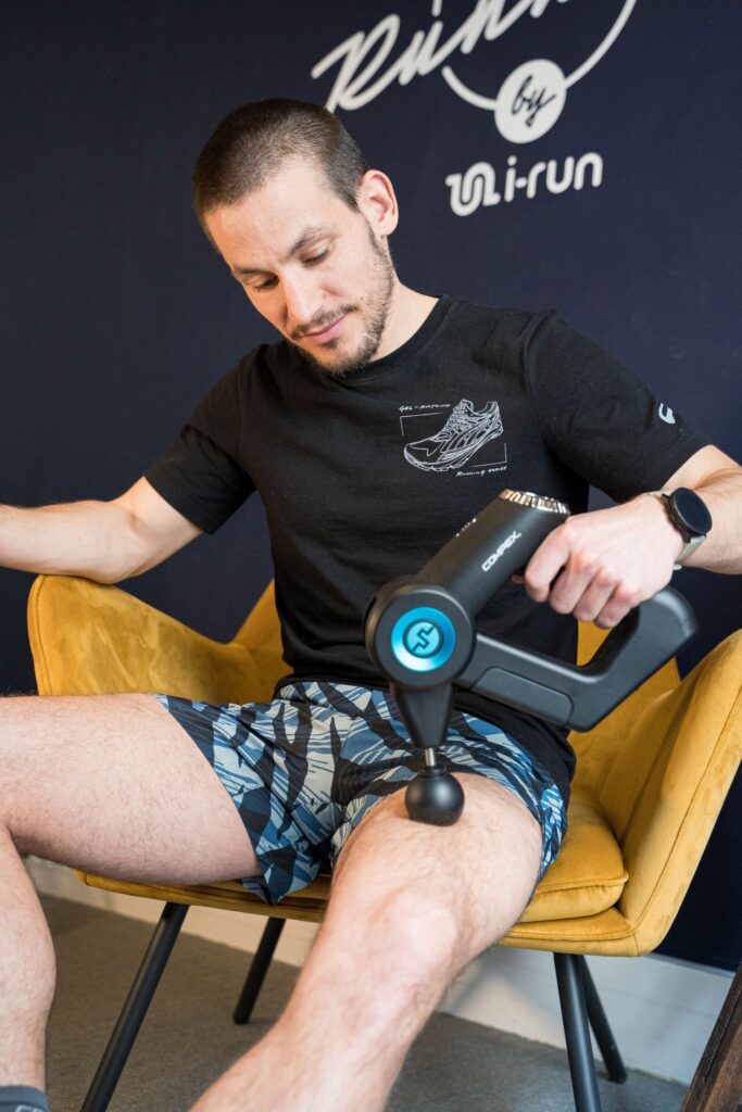 un homme qui se masse la cuisse avec un pitolet de massage compex fixx