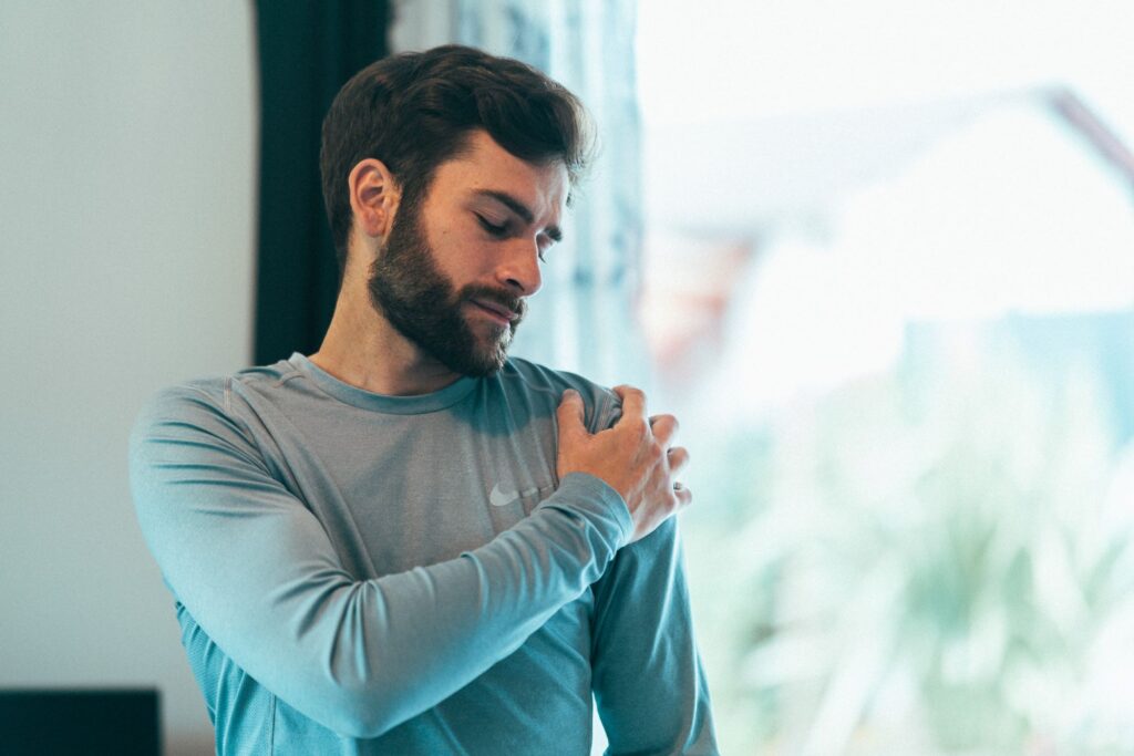 un homme avec une douleur à l'épaule, qui va la soulager avec l'électrostimulation