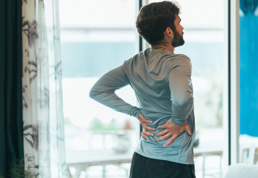 un homme qui se tient le dos car il a de l'arthrose