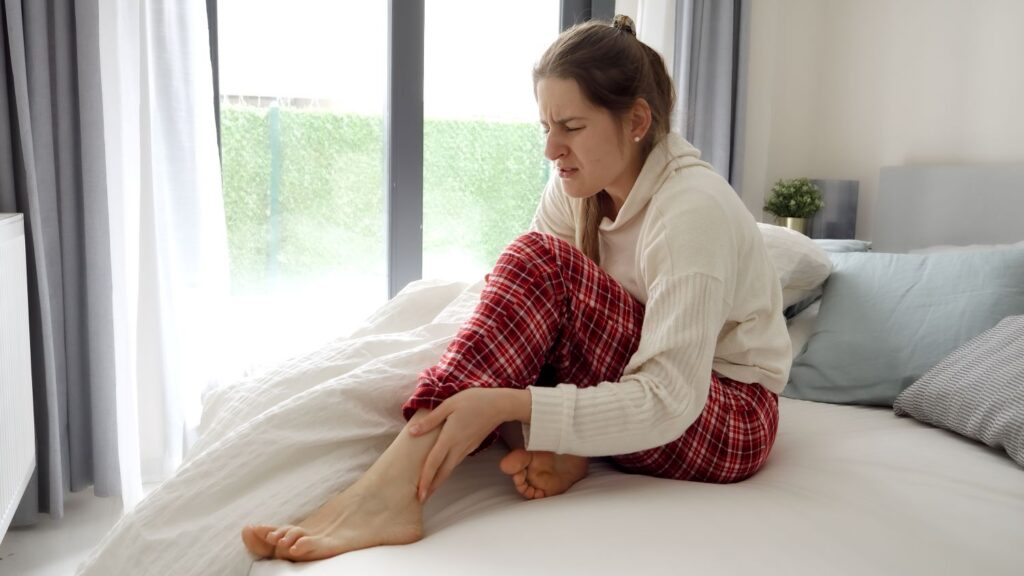 une femme qui souffre de crampes nocturnes aux jambes