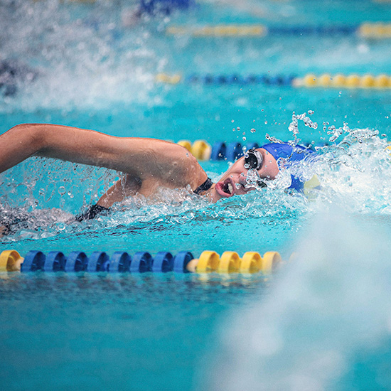 Swimmer taking a breath while swimming laps in olympic pool