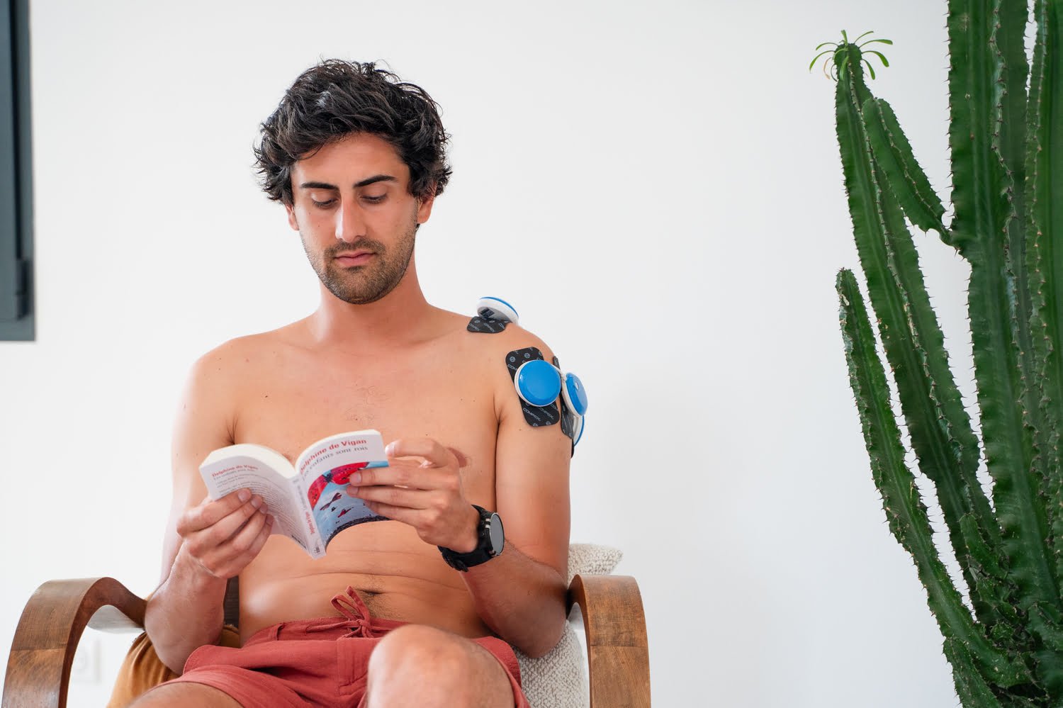 A man treating Shoulder Tendinopathy using the Compex FIT 5.0 electrostimulator