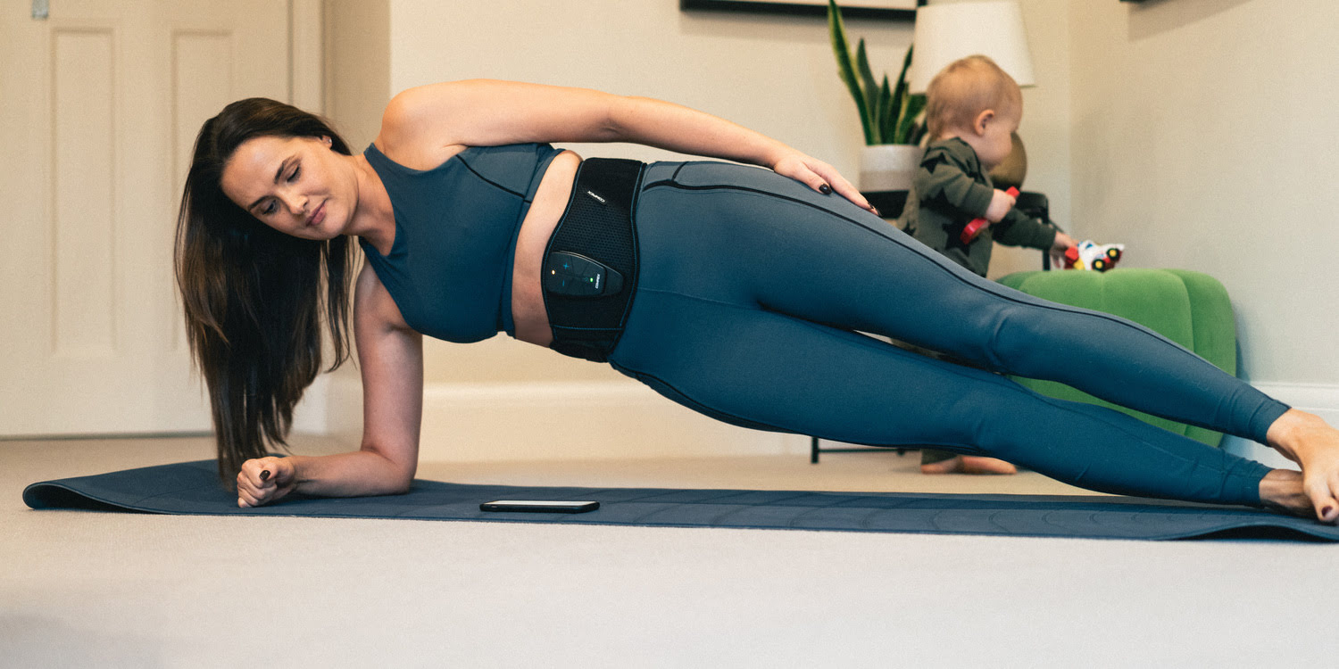 A woman doing a side plank using Compex Corebelt