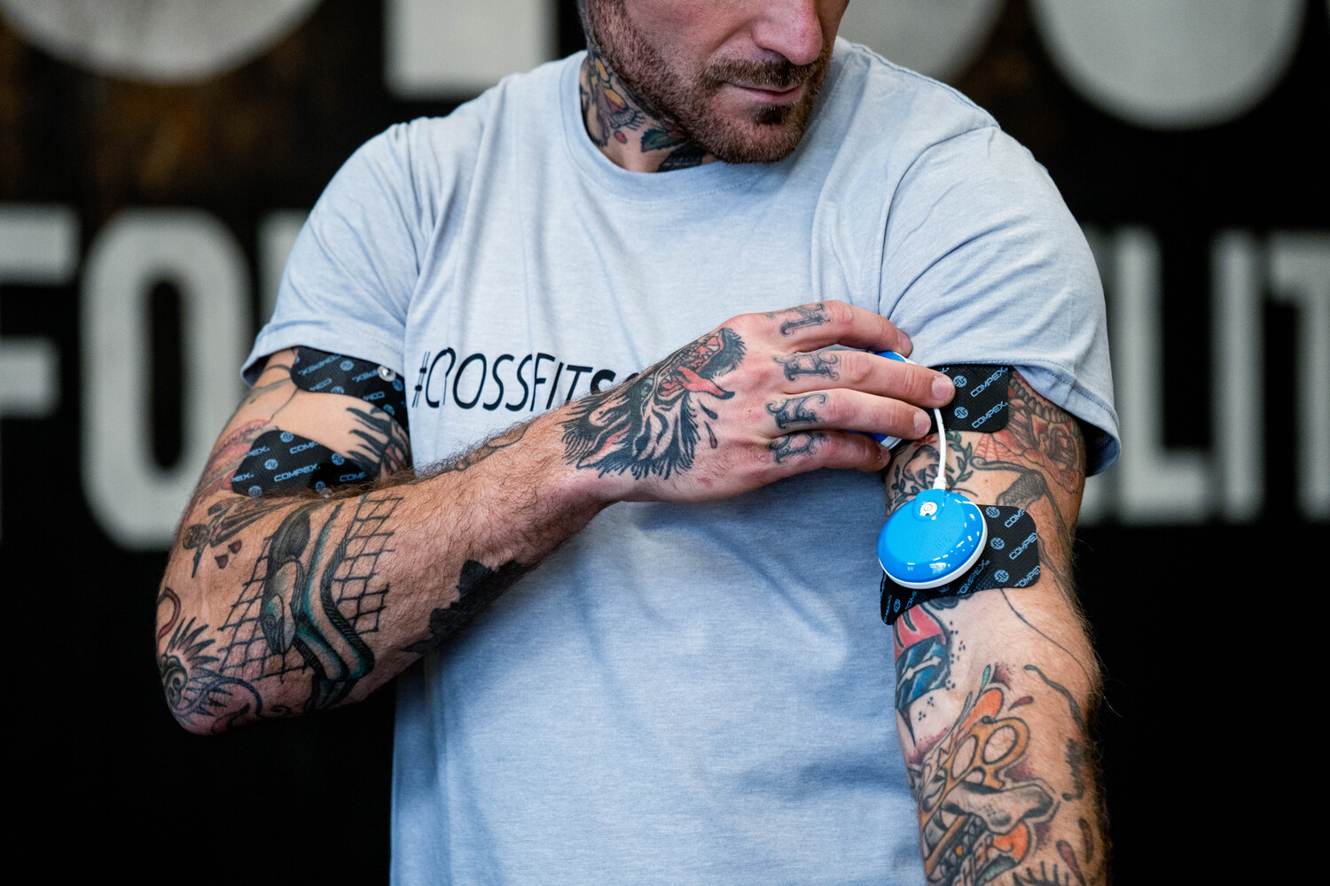 A man placing his modules before a workout with the Compex FIT 5.0 muscle stimulator